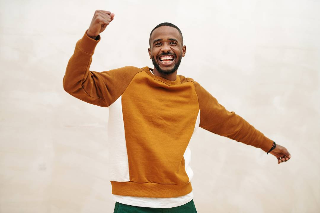 a happy black man smiling and thinking about oral or intravenous administration of nac supplementation, the health benefits and related mental health conditions - The Good Stuff