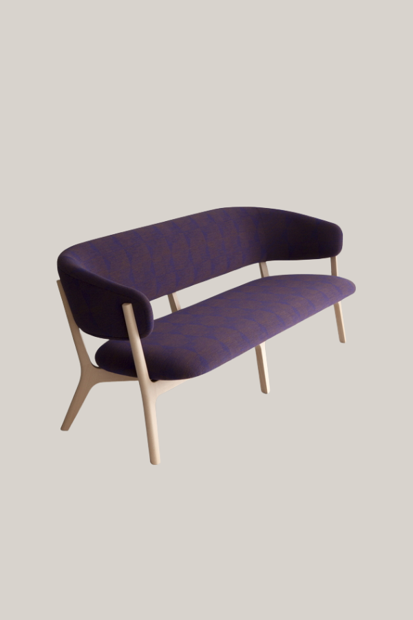 Elegant Japanese sofa featuring a curved upholstered backrest and seat in deep purple fabric with light wood legs and soft organic lines