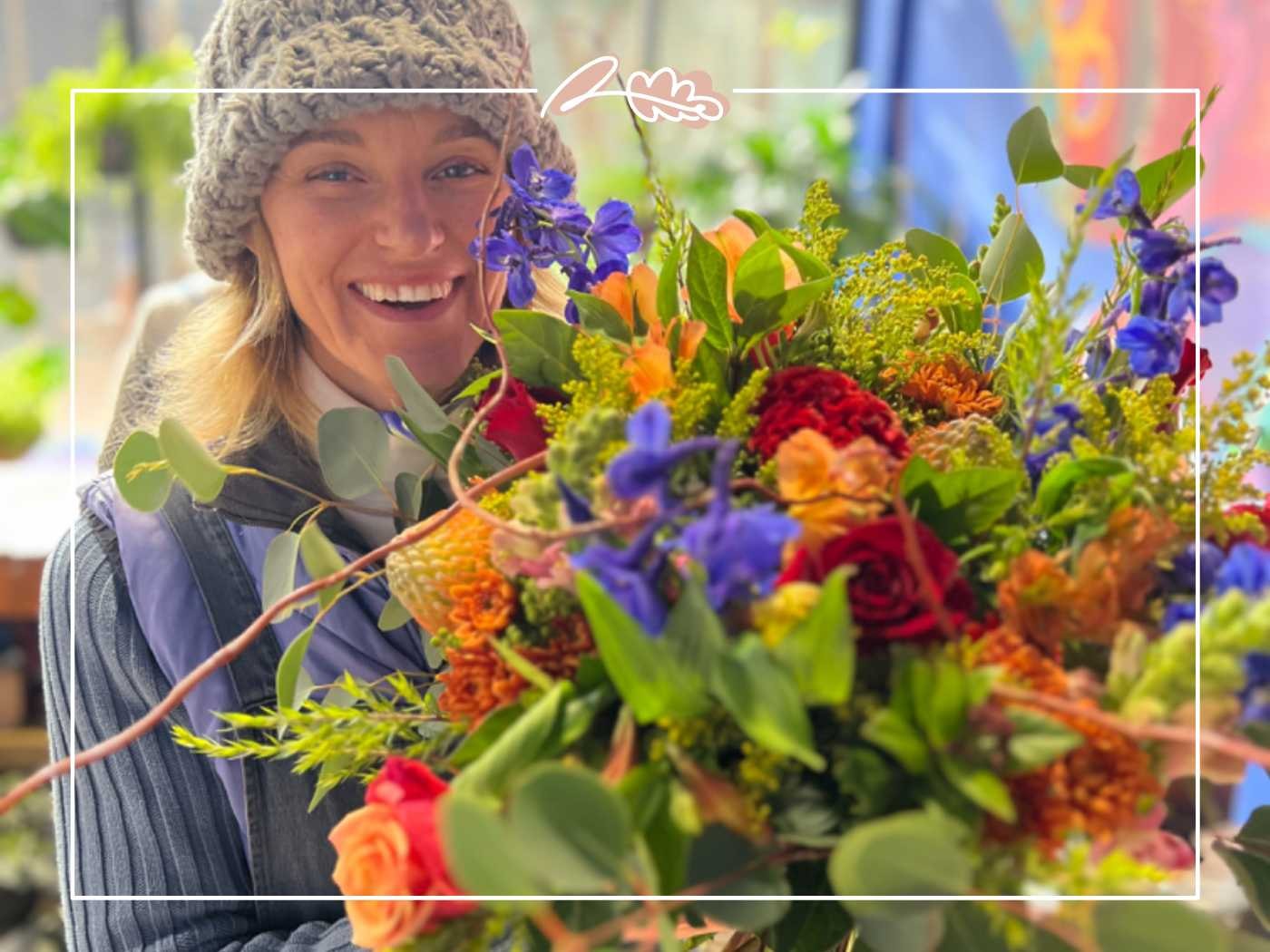 Florist smiling with a colorful mixed flower bouquet by Fabulous Flowers and Gifts