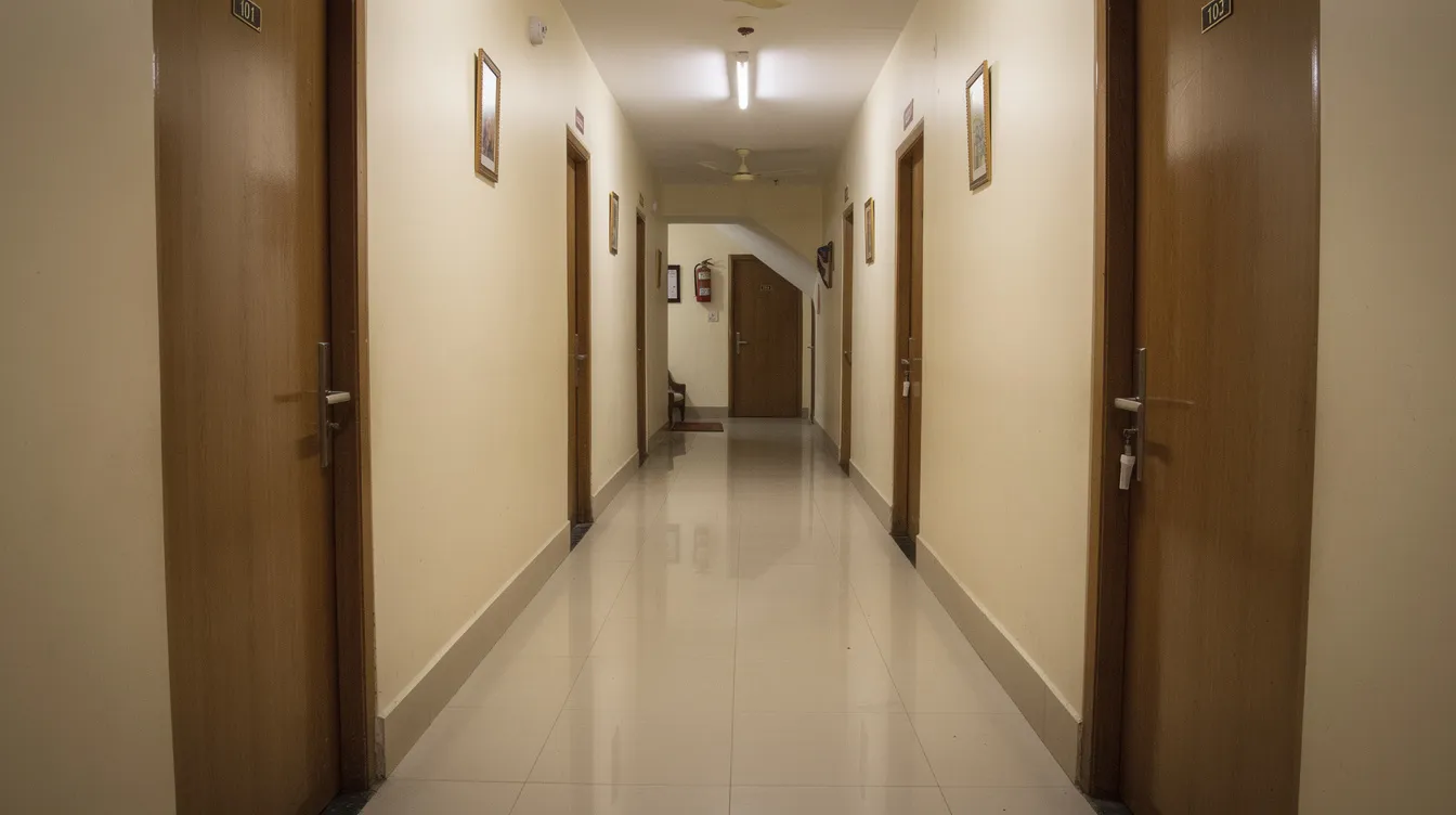 716c9db8 4a44 41e2 b345 2e7c10565d88 The image depicts a hotel corridor in a small Indian hotel, featuring neatly numbered room doors and clean, polished flooring. This setup reflects the essential elements of hotel construction costs and the hospitality industry, emphasizing a welcoming environment for guests.