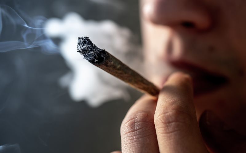 close up of man smoking cannabis joint