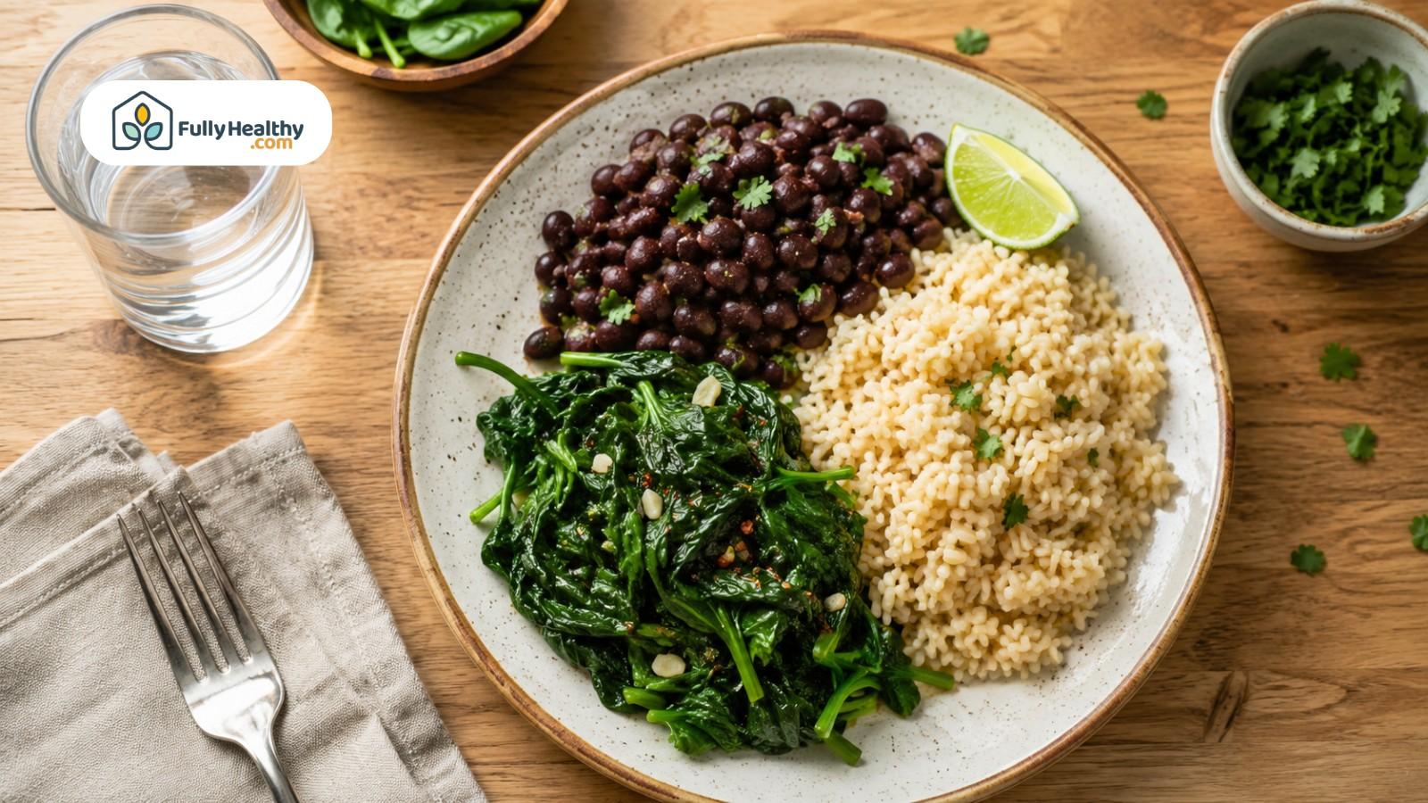Balanced meal with cooked spinach, black beans, grains, and water