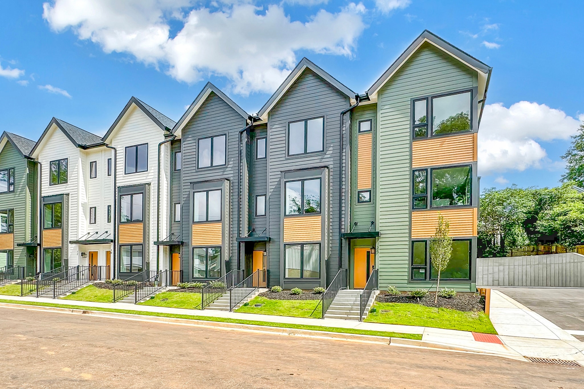 Row of newly built modern multifamily townhomes with large windows, clean design, and landscaped front entrances in Greenville, SC