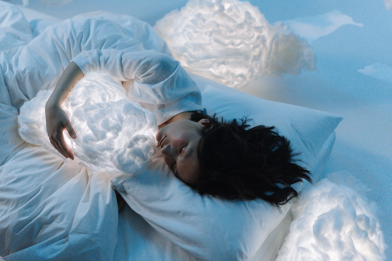 Ultimate Guide To Meditation For Sleep: Woman sleeping with cloud shaped cushions