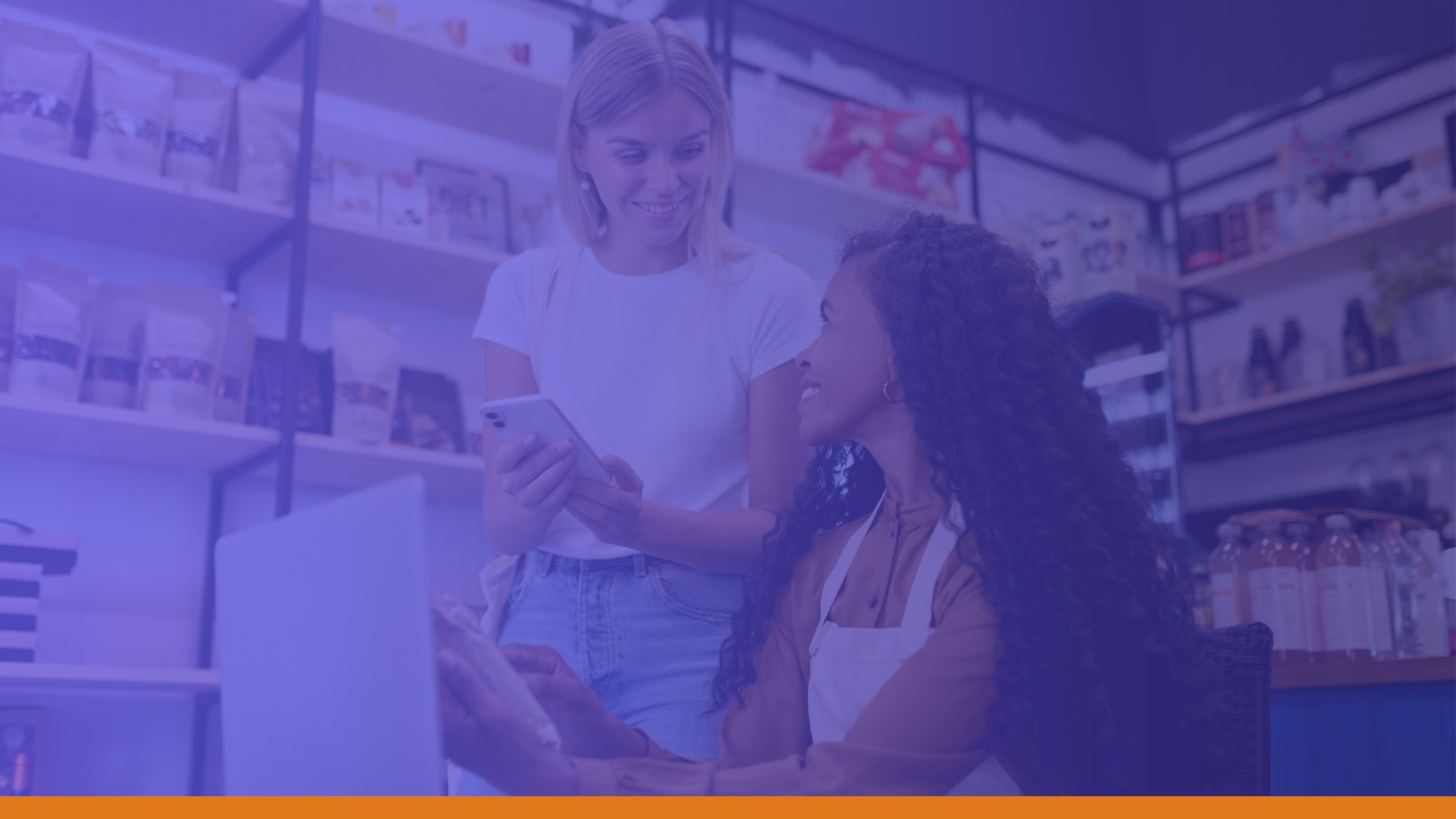 Two female retail team members reviewing a phone screen in-store, representing retail organizations improving communication with store teams and emergency notification tools.