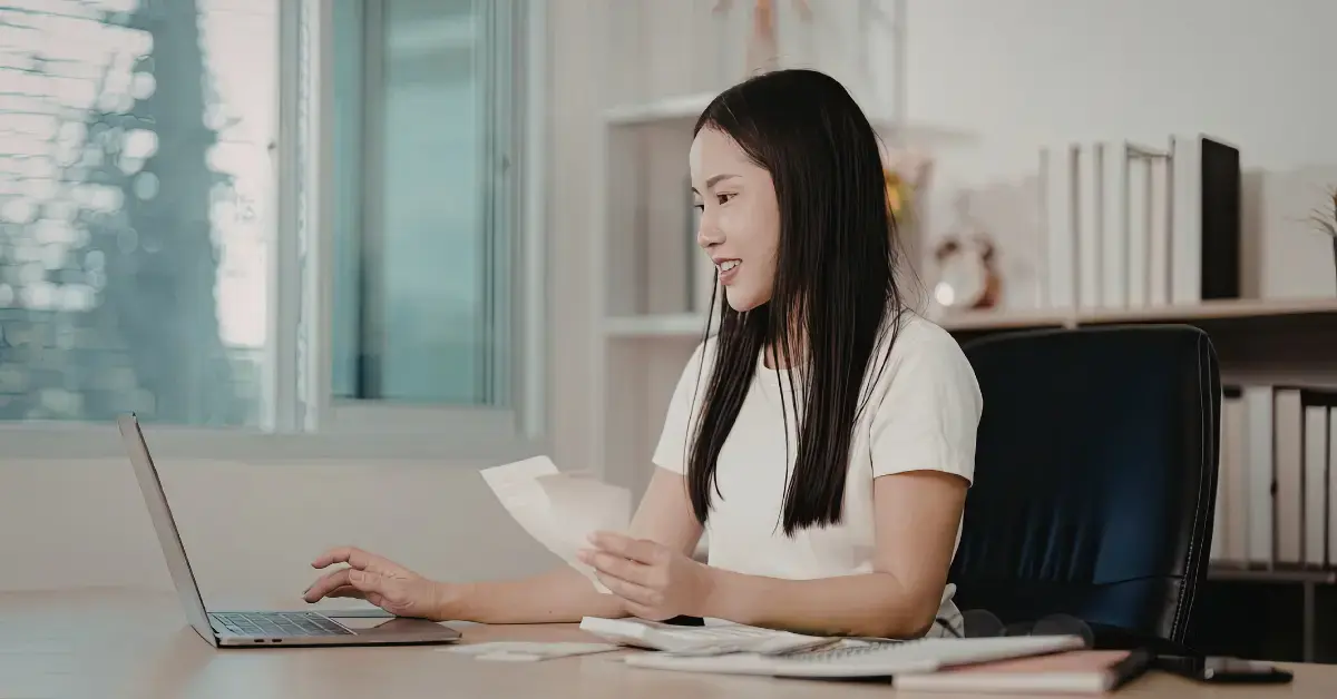 Woman organizing business expenses and Form 433-A paperwork for IRS payment plan review.