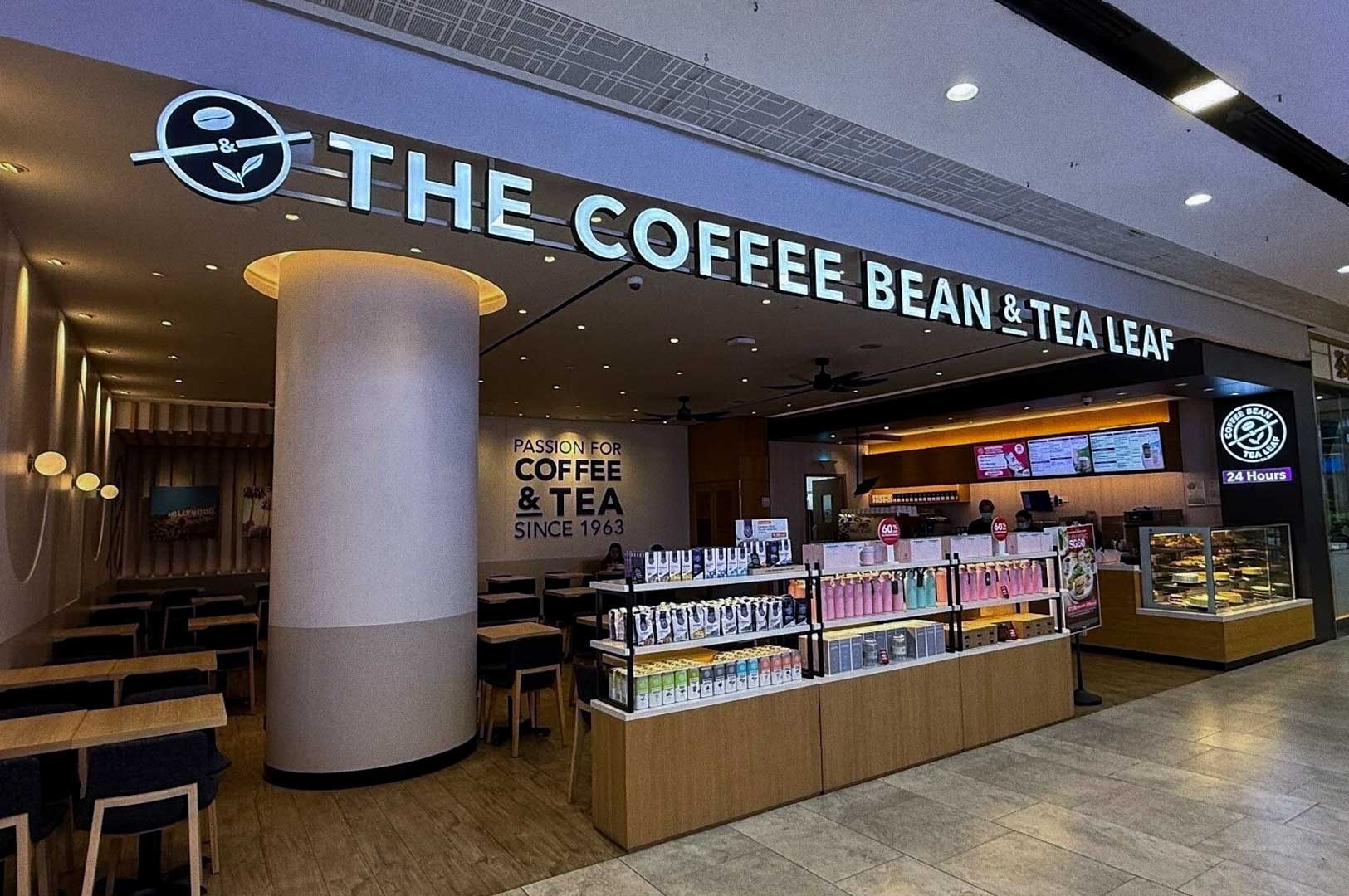 The Coffee Bean & Tea Leaf storefront at Tampines Central with illuminated brand sign, glass windows showing interior seating and pastry display, and a 24‑hour open sign.
