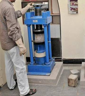 A technician testing the compressive strength of concrete