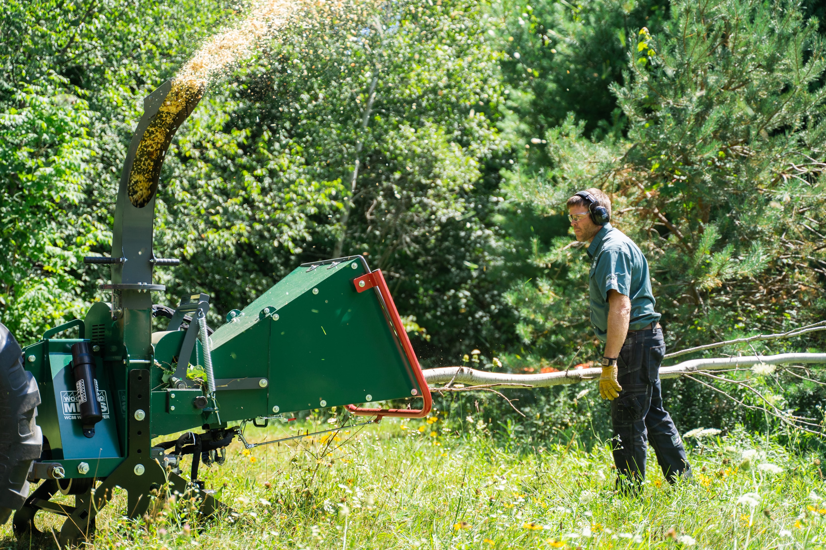 An example of tree branches being fed into a Woodland Mills wood chipper.