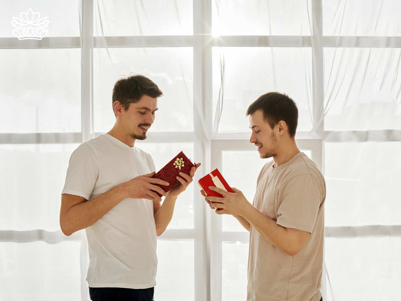 Two men exchanging gifts by a bright window, smiling as they share a joyful moment, reflecting love and care on a special occasion. Fabulous Flowers and Gifts. Delivered with Heart. Delivery Valentine's Day gifts.