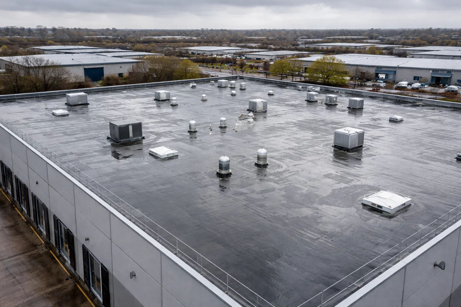 Commercial flat roofing system in Greater Manchester showing standing water after heavy rain.
