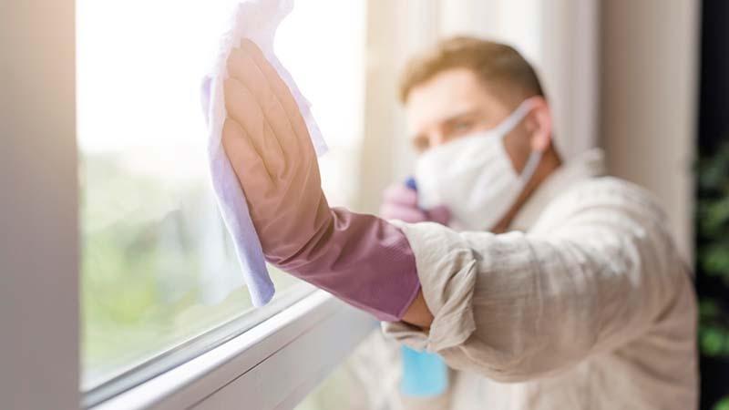 A man is cleaning windows with a microfiber towel