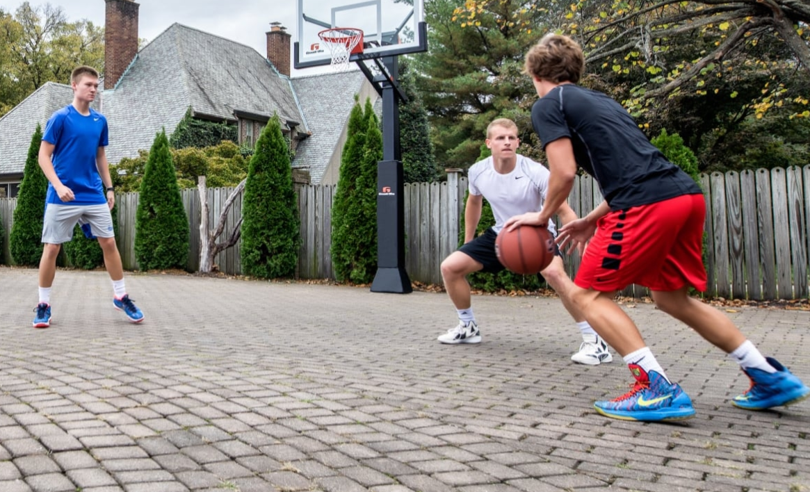 family playing basketball in their driveway