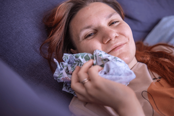 a woman applies a cold compress to face after tooth extraction