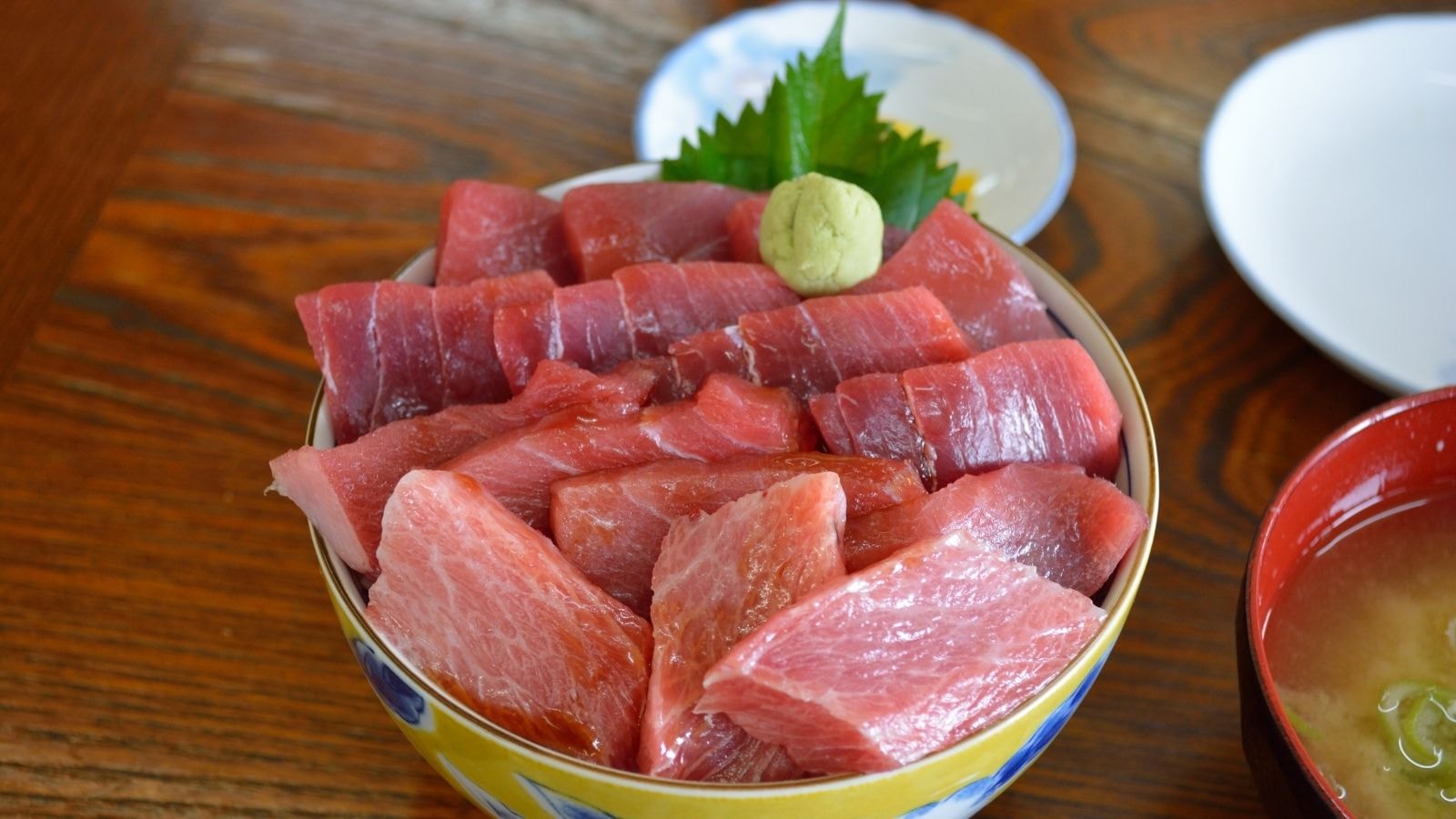 A bowl of fresh tuna sashimi with wasabi and soup