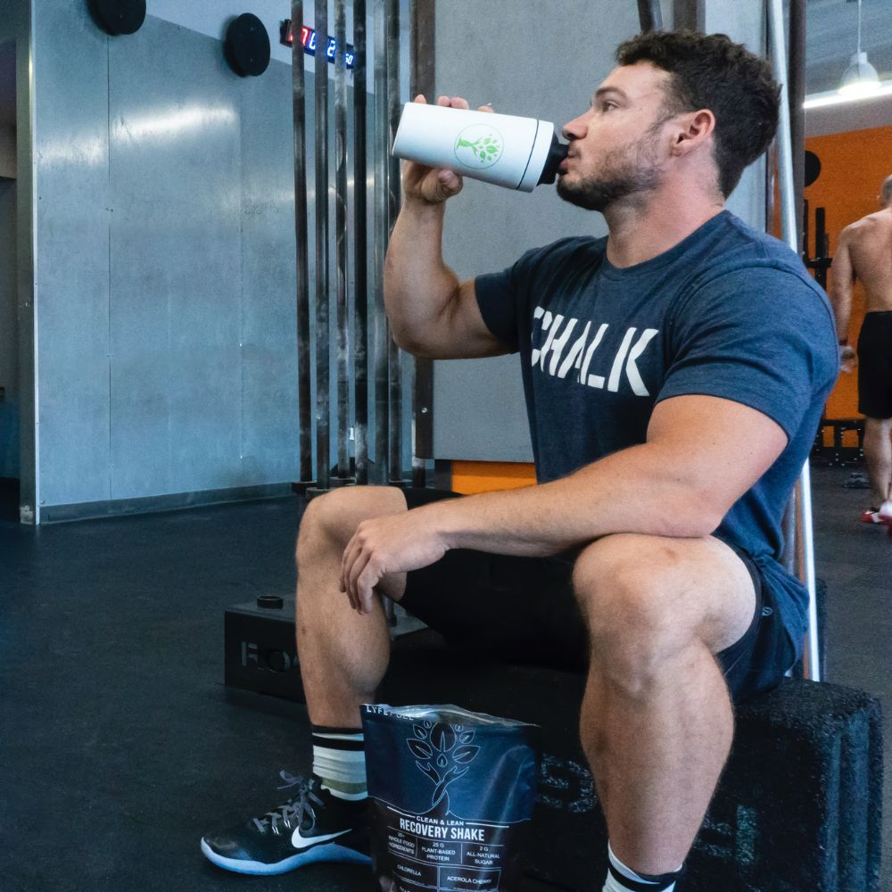 A person drinking a protein shake and looking happy