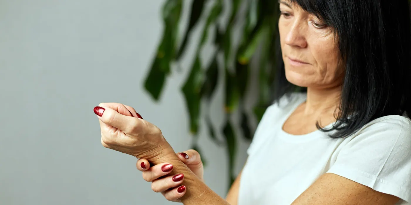 Frau mit Arthrose im Handgelenk - Wie Kurkuma helfen kann