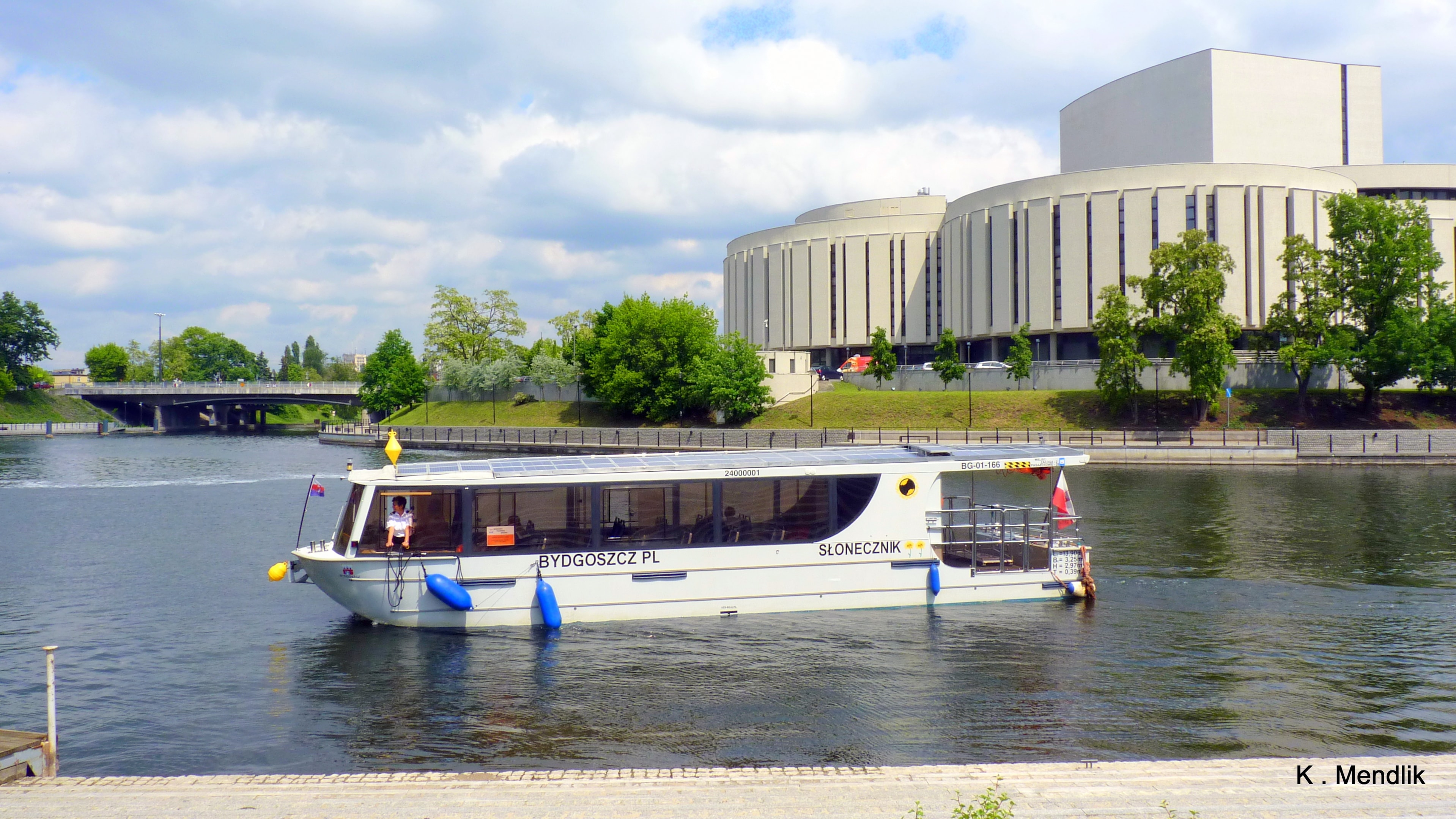 Rejsy tramwajem wodnym w Bydgoszczy (źródło: https://commons.wikimedia.org/wiki/File:Rzeka_Brda_,S%C5%82onecznik_p%C5%82ynie_do_przystanku_na_Wyspie_M%C5%82y%C5%84skiej_-_panoramio.jpg)