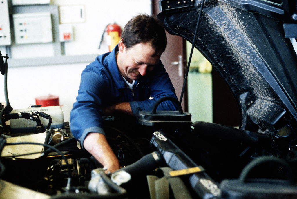 A mechanic inspecting a car for recall repairs