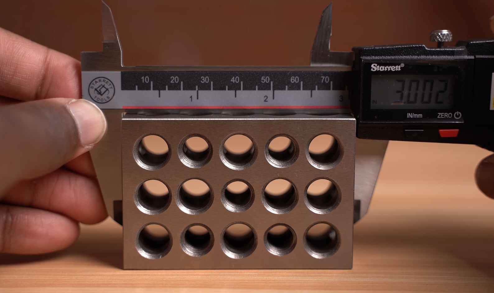 using Starrett caliper to measure the outside of a 3 inch block