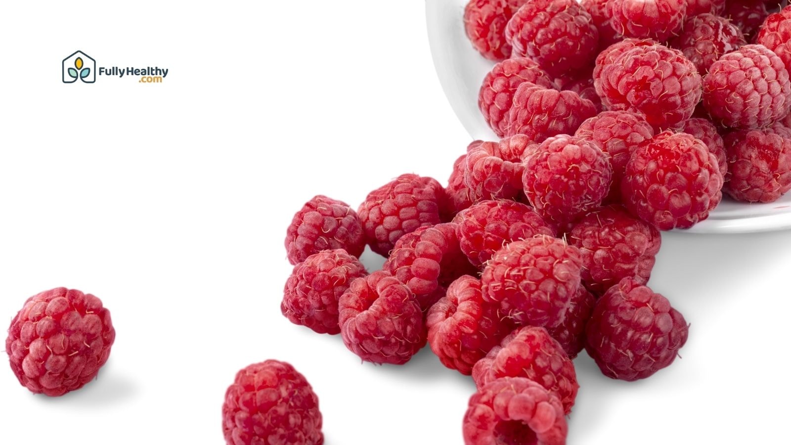 Fresh raspberries spilling from a white bowl on a white background