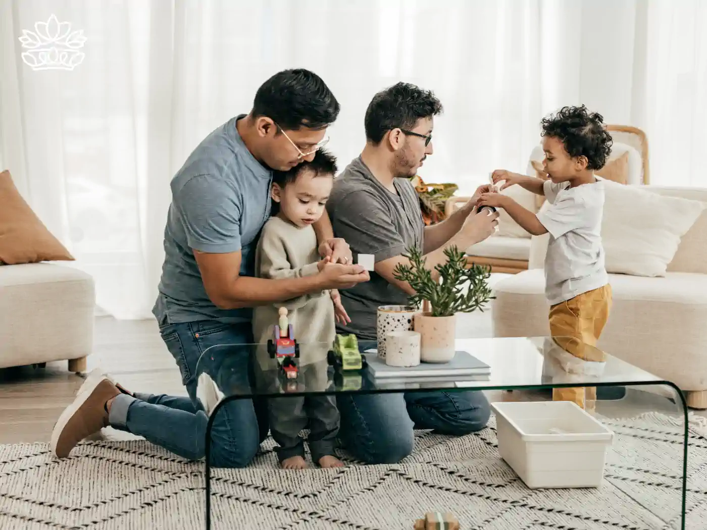 A same-sex couple playing with their children in a modern living room, depicting family love. Fabulous Flowers and Gifts - Pride Collection.