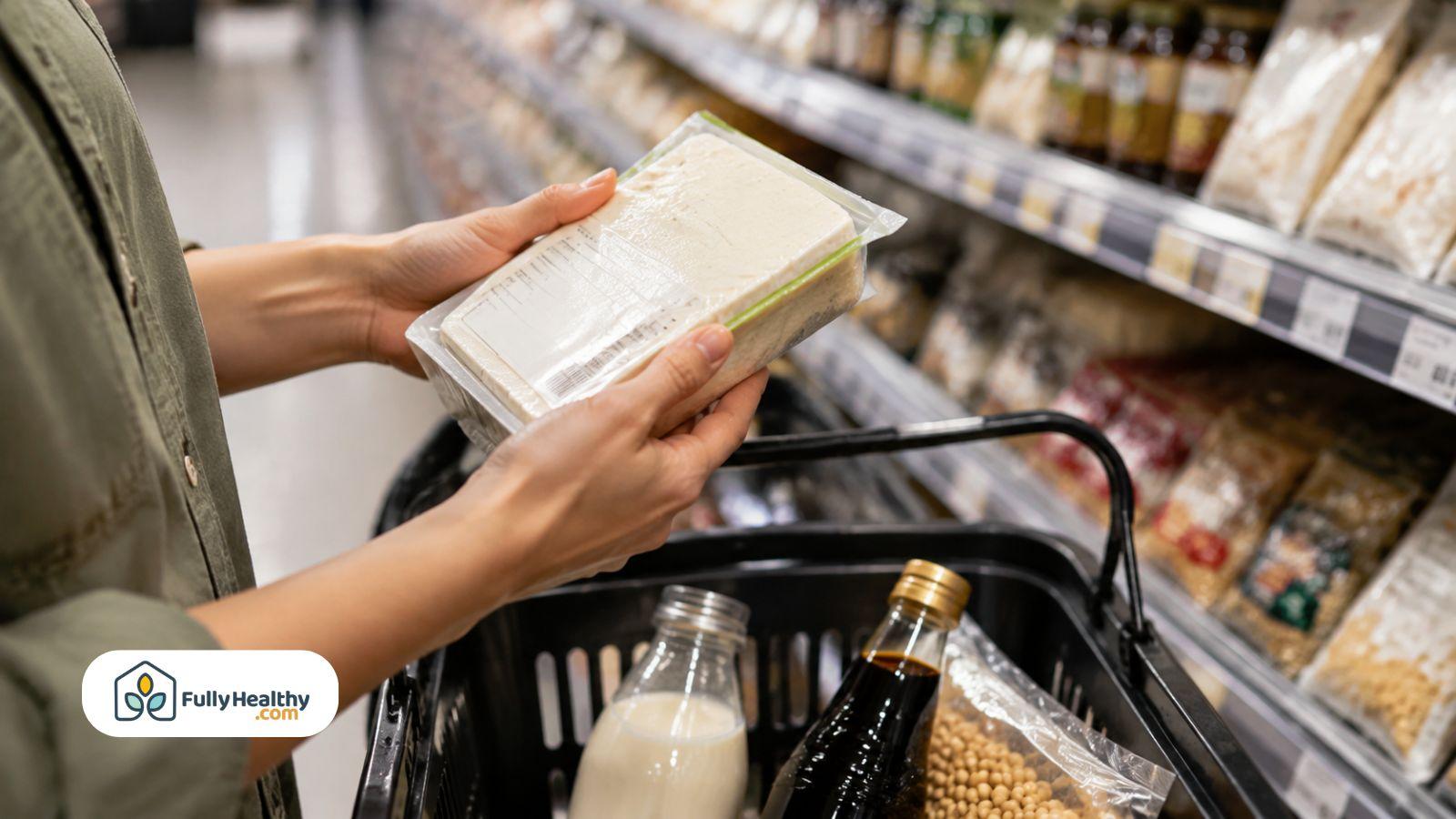 Shopper checking packaged tofu ingredients beside basket of soy products