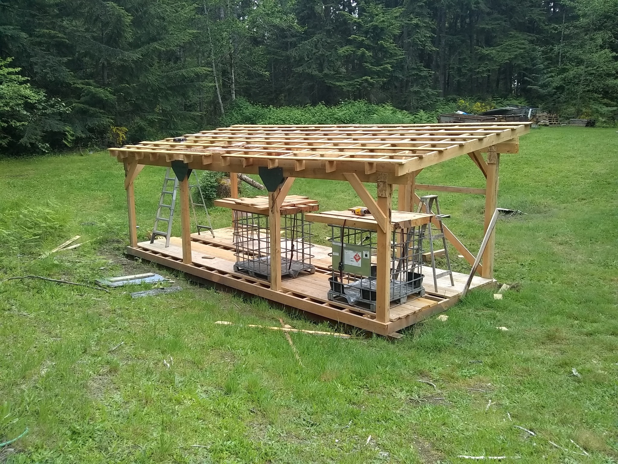 A sawmill shed mid-construction, with clearance on one side for logs to be loaded in.