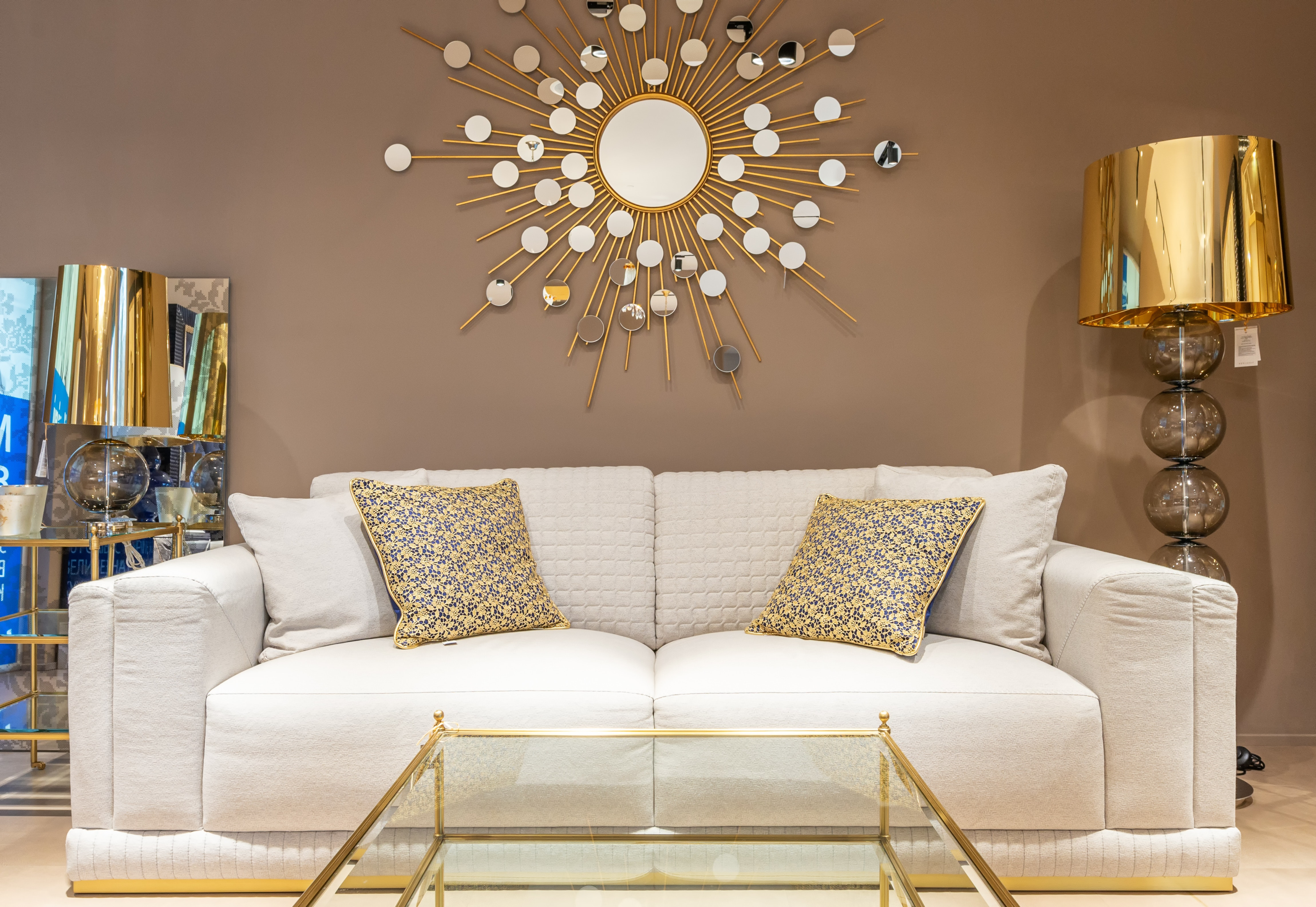 statement mirror on wall above white sofa