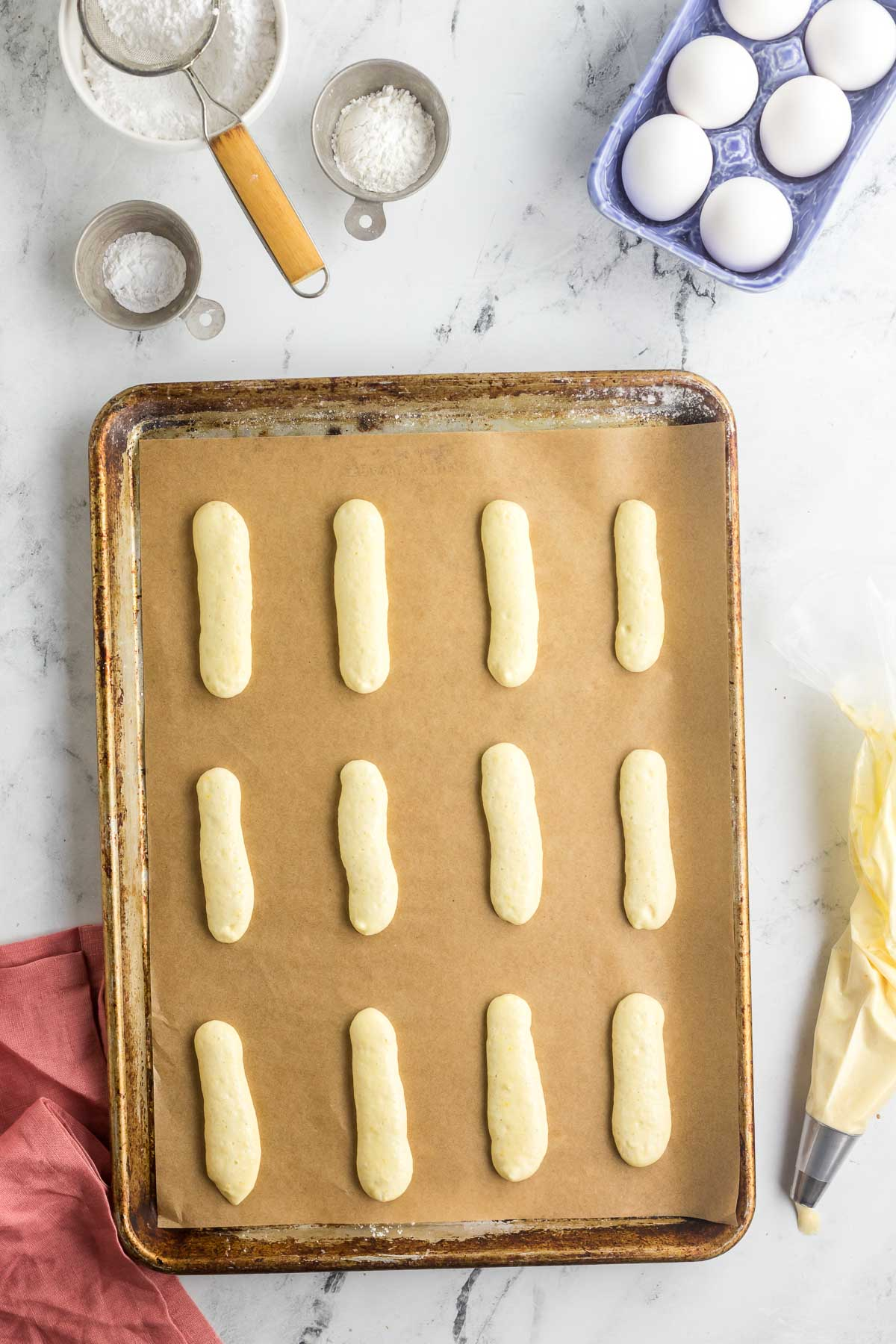 piped lady finger cookies on a baking sheet
