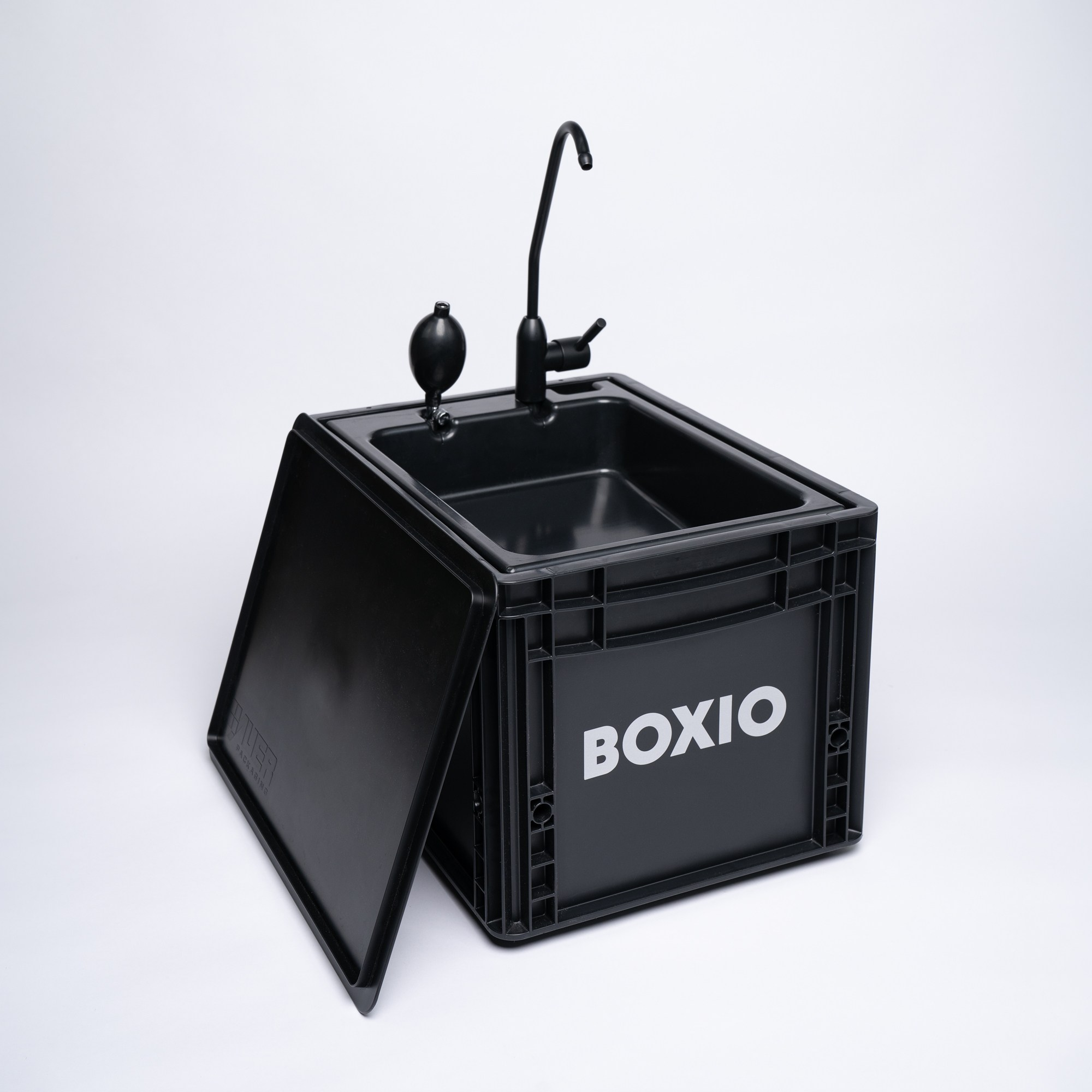 BOXIO-Wash Komplettansicht: schwarze Eurobox mit umgeklapptem Deckel, Pumpe und Wasserhahn