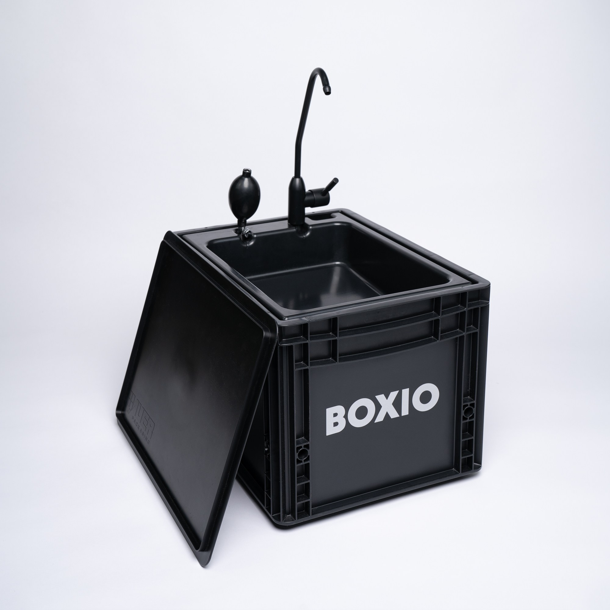 BOXIO-Wash Komplettansicht: schwarze Eurobox mit umgeklapptem Deckel, Pumpe und Wasserhahn 