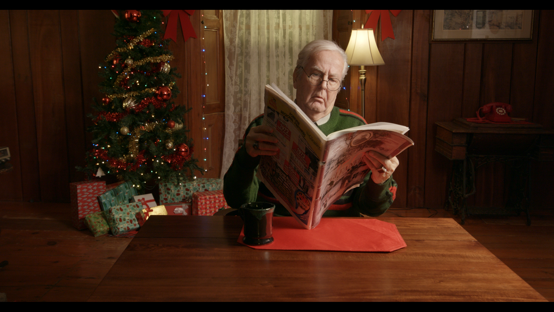 An old man reading a newspaper on Christmas day