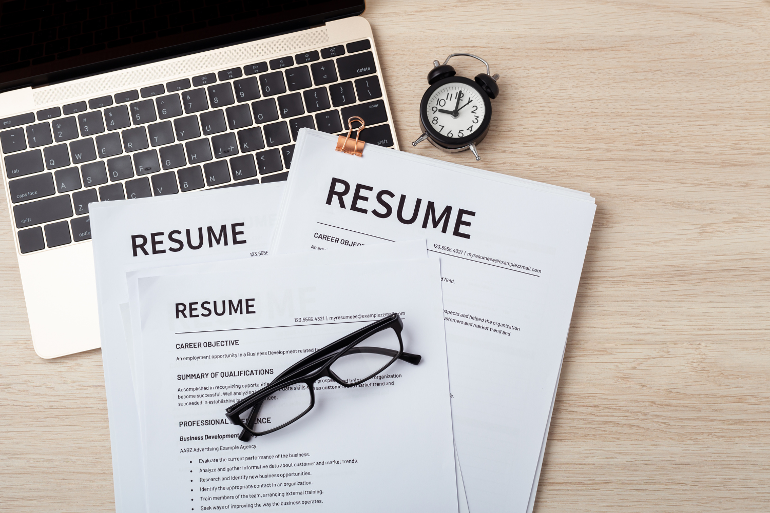 Two resumes on a desk.