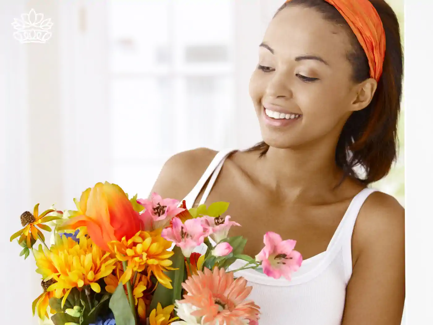 Young woman smiling brightly while holding a vibrant floral arrangement in her hands. Fabulous Flowers and Gifts, Luxury Flower Arrangements.