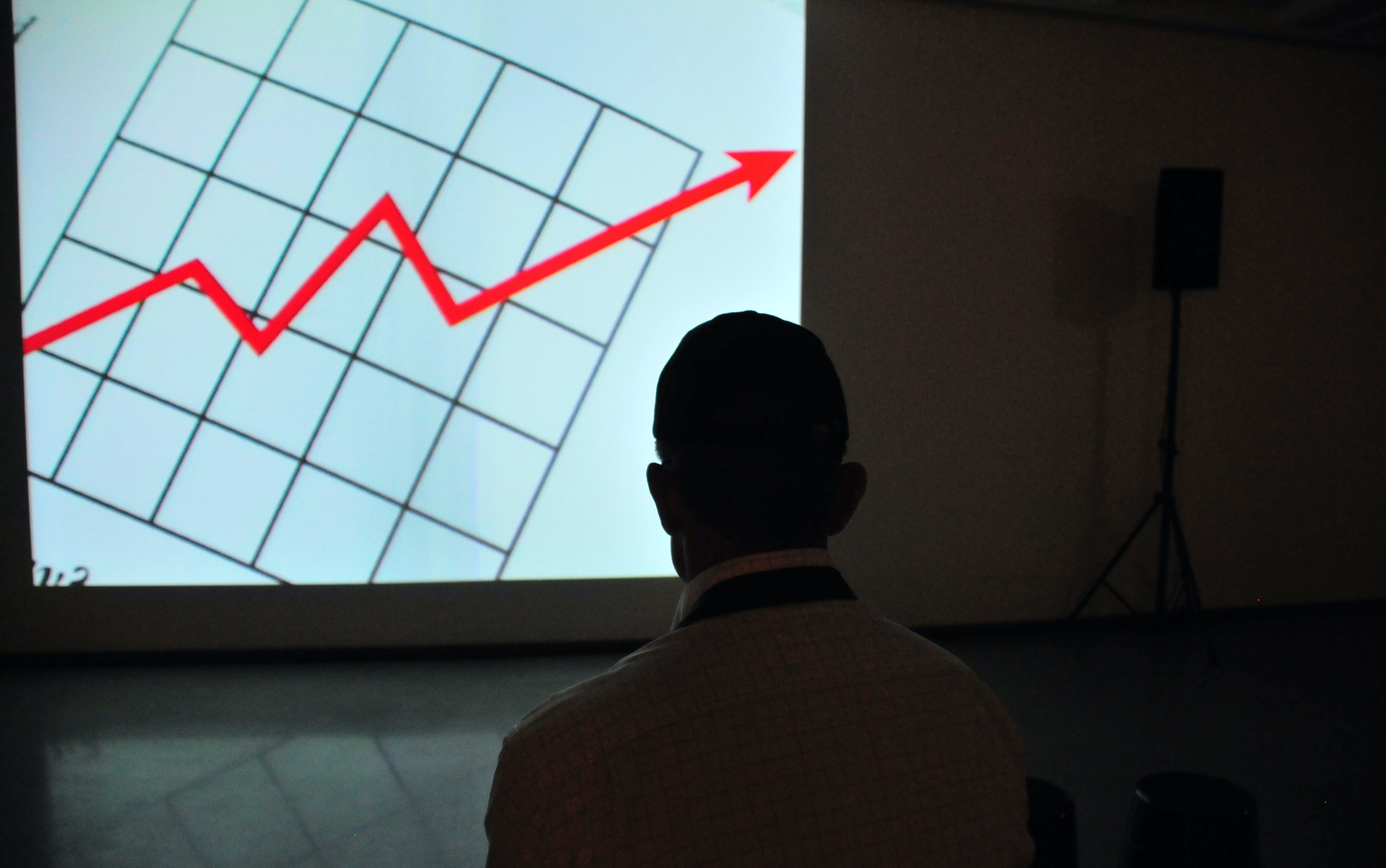 Photo of a man looking at an upward trend graph