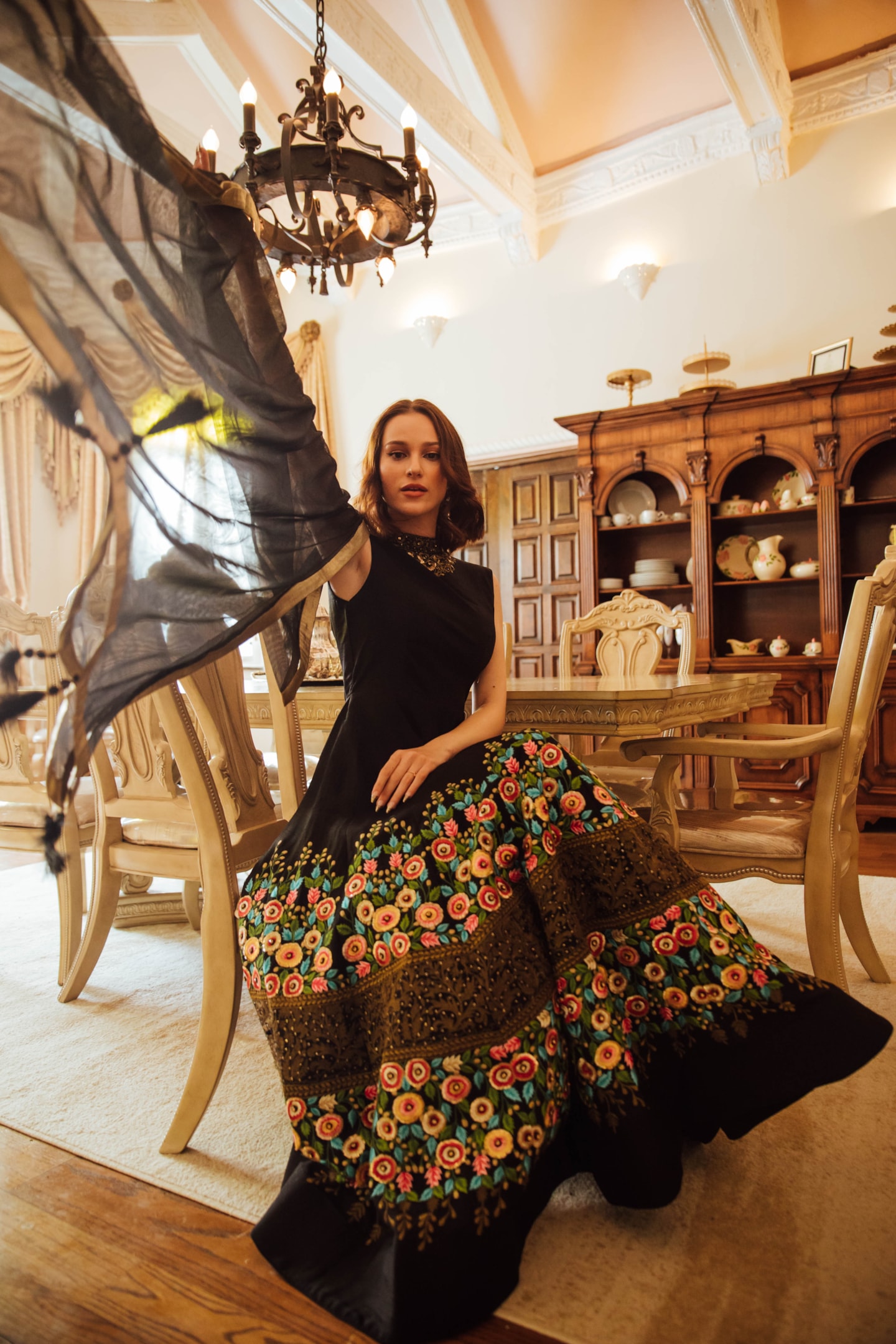 A beautiful black floral embroidered evening gown on a mannequin.