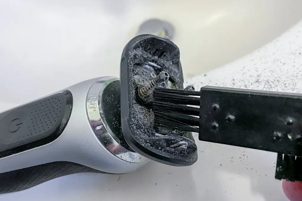 A modern electric razors or most electric razors being cleaned to maintain blades sharp with mineral oil