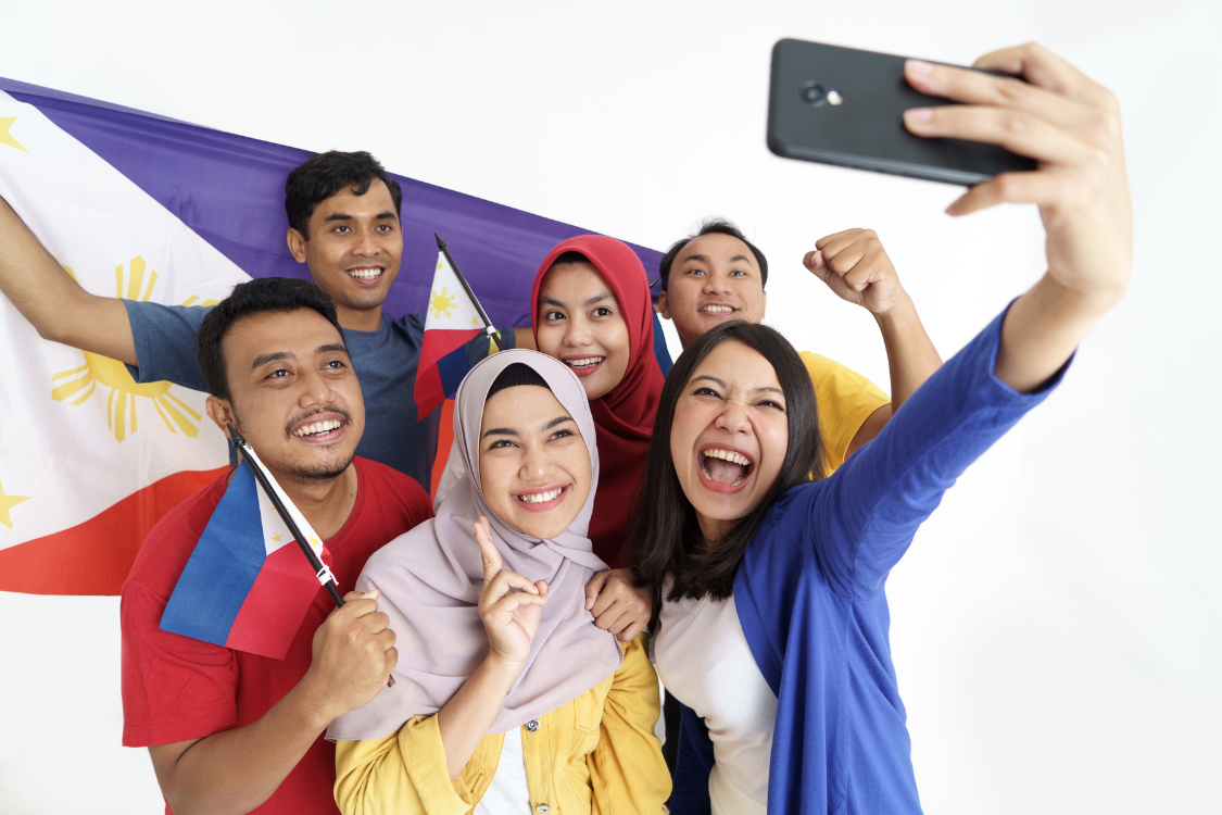 Group of Filipino remote workers celebrating with Philippine flags
