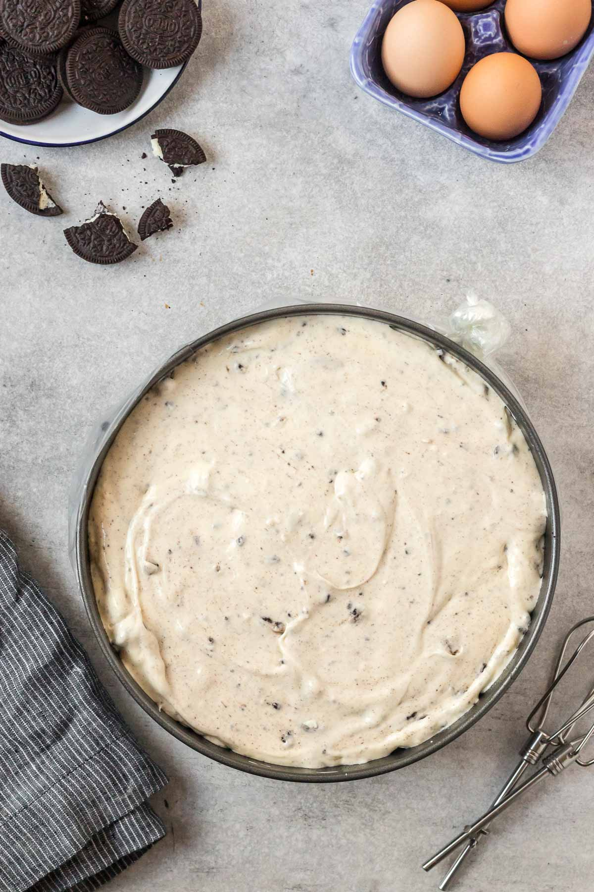 Oreo cheesecake batter spread into springform pan