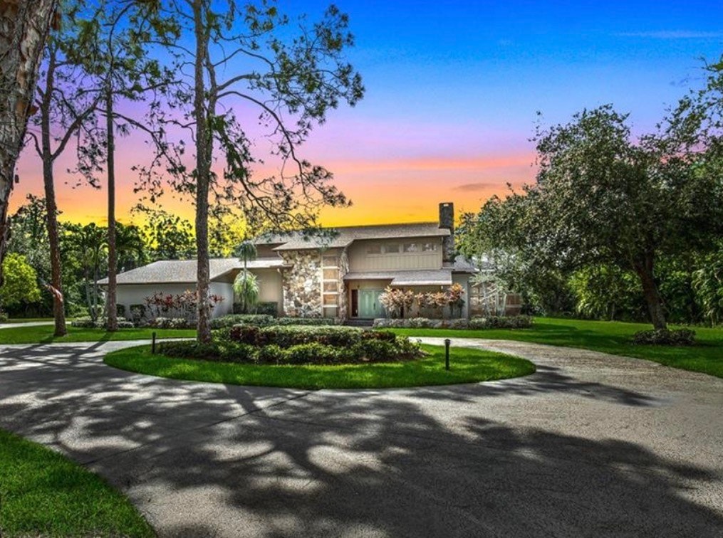 A winding road lined with towering pines creates a natural canopy, inviting you to explore the serene beauty of Livingston Woods in Naples. This picturesque setting offers an expansive outdoor living experience, perfect for those seeking tranquility in a vibrant community.