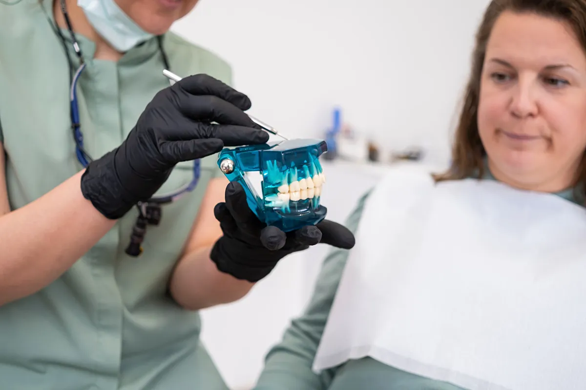 Dentist demonstrating dental appliance to patient in clinical setting