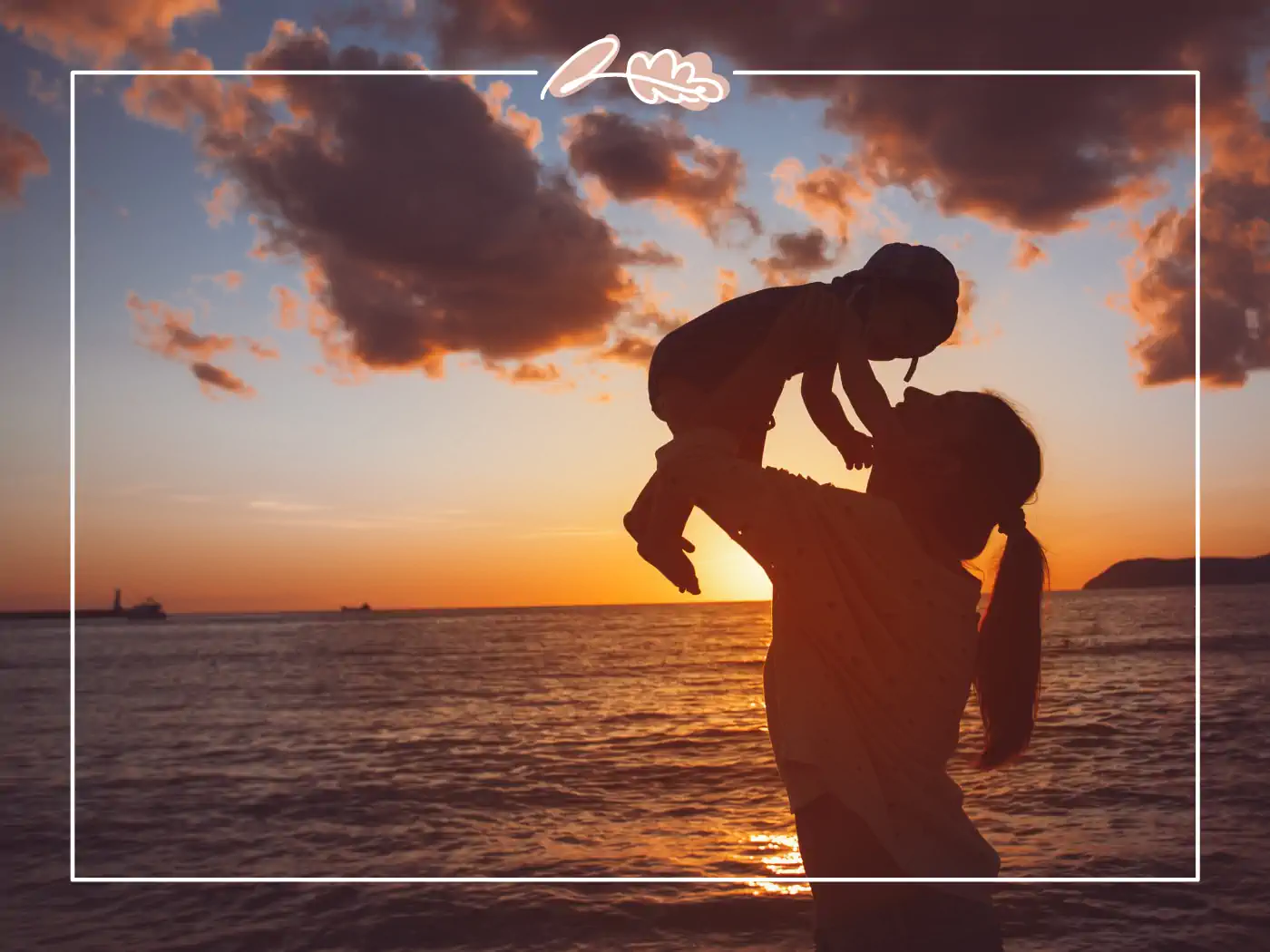 Silhouette of a mother lifting her child at sunset on the beach, fabulous flowers and gifts