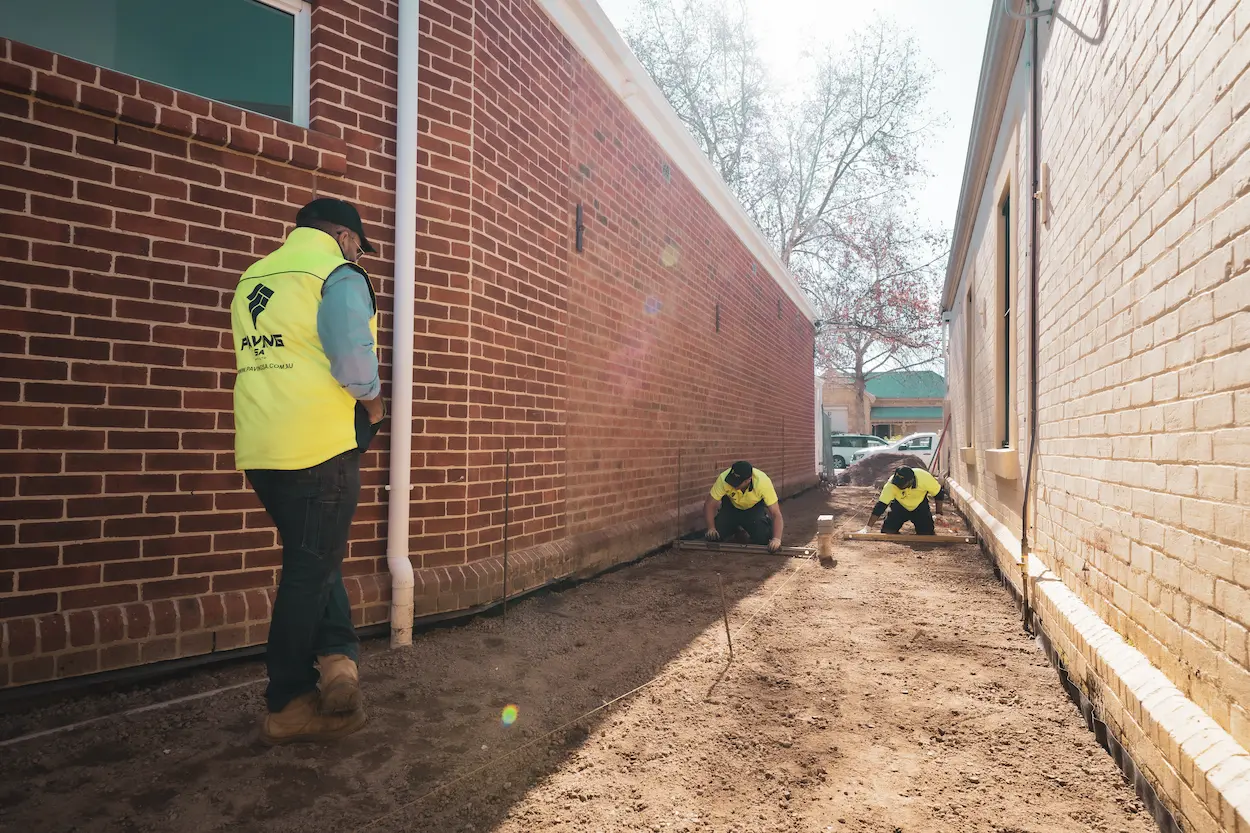 A layer of crushed stone being spread over the base material