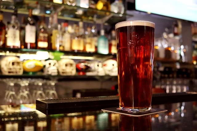 Photograph of a glass of traditional English ale on a bar counter
