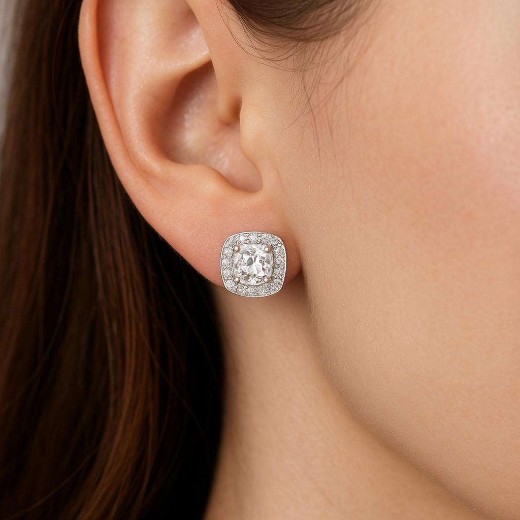 Auskarai su pagalvėlės formos (cushion cut) deimantu ir halo dizainu, balto aukso įtvirtinimas, ant stilingos merginos ausies