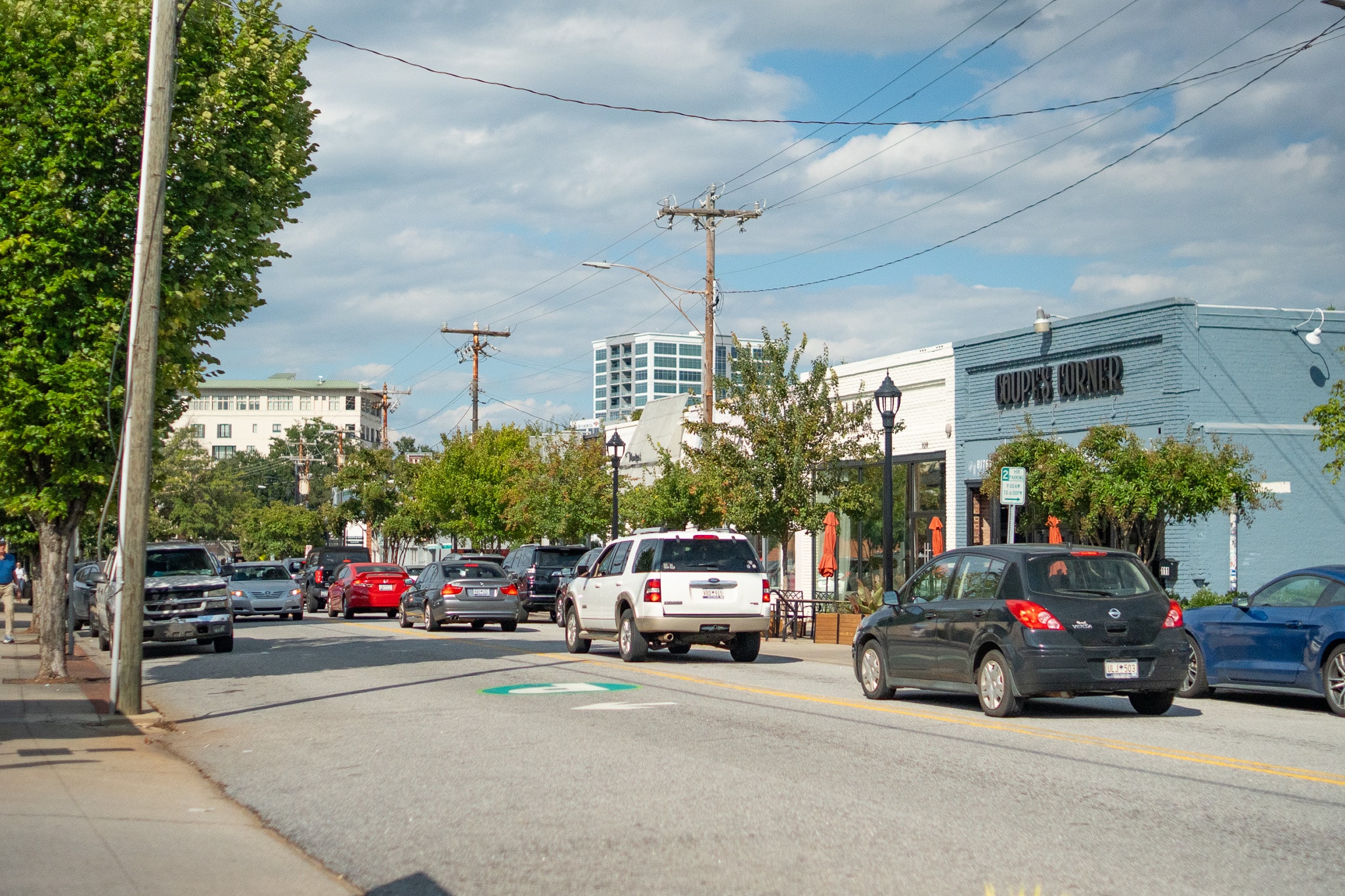 In this image, cyclists and walkers are enjoying the scenic Swamp Rabbit Trail in Greenville, South Carolina, surrounded by lush greenery and a vibrant atmosphere. The trail is a popular outdoor destination for families and residents, offering a community space for recreation near downtown Greenville.
