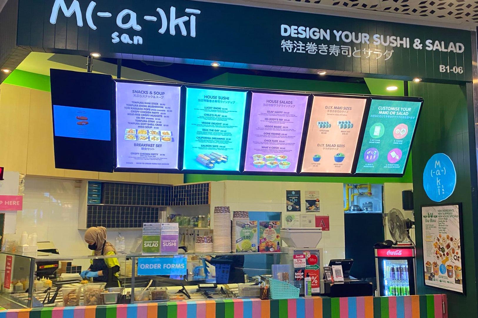 Maki San sushi counter with menu boards in Singapore.