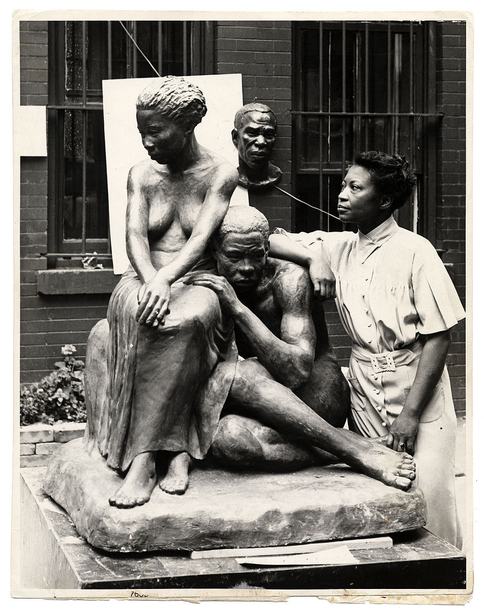 Photo of the African-American sculptor with her work. Augusta began making figures in her early fine arts career.