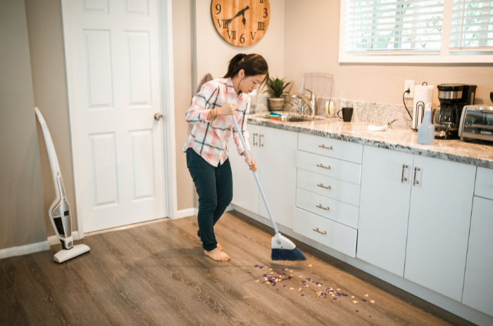 woman using broom to sweep